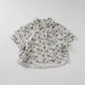 Detailopname van de abstracte kiezelprint en katoen-linnen textuur op dit kinderoverhemd - 80cm / Lichtblauw
