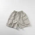 Detail view of children's cargo shorts featuring elastic waist and large flap pockets - 80cm / Beige Grey