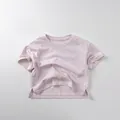 Detail view of the side slit hem on a light purple cotton short sleeve T-shirt - 80cm / Cream Pink