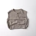 Detail van mouwloze katoenen gaas-top voor kinderen met textuurstof en knoopsluiting - 80cm / Khaki