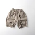 Detail of khaki cotton leisure shorts featuring elastic waist and BOOK stencil print - Khaki / 80cm