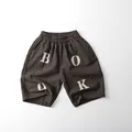 Detailed view of kids cotton linen cropped pants featuring an elastic waist and BOOK print - Grey Coffee / 80cm
