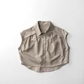 Dettaglio in piano di una camicia smanicata in cotone beige con colletto e taschino - 80cm / Cachi