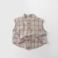 Détail d'une chemise sans manches à carreaux pour enfants avec col officier et poche avant - 80cm / Carreaux Kaki