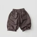 Detail of breathable linen blend shorts for kids featuring elastic waist and large patch pocket - 80cm / Brown