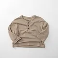 Close-up of soft cotton kids long sleeve Henley shirt with classic three-button neck detail - 80cm / Khaki