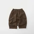 Dettaglio dei pantaloni cargo per bambini in cotone con vita elastica e grandi tasche laterali - 80cm / Marrone Scuro