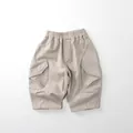 Dettaglio della vita elastica e delle tasche cargo sui pantaloni in cotone per bambini - 80cm / Beige