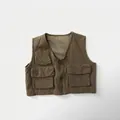 Detailed close-up of a vintage utility vest featuring multiple pockets and durable cotton fabric - 80cm / Khaki Green