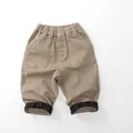 Detail of children khaki trousers featuring elastic waist and striped cuff lining - 80cm / Khaki