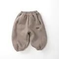 Detail der warmen Kinder-Fleece-Jogginghose in Hellbraun mit Gummibund und Buchstabendruck - Khaki / 80cm