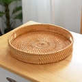 Vista dettagliata di un vassoio rotondo in rattan intrecciato a mano con manici su un tavolo - Piccolo (29cm*4cm) / Marrone Legno