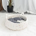Detailansicht eines gewebten Katzenkorbs mit Ohrengriffen und buntem abstrakten Kissen - Katzenbett mit Baumwollmatte / Weiß mit bunten Punkten / Klein 34*13