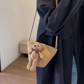 Beigefarbene gewebte Stroh-Umhängetasche mit einer niedlichen braunen Bärenpuppe - Khaki