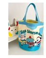 Detail of canvas bucket bag showing colorful animal ice skating club illustration and blue handles - Three Skating Animals