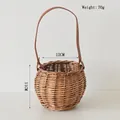 Dettaglio di cesto in vimini intrecciato con manico in pelle marrone scuro e rivetti dorati - Stile con manico in pelle