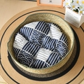 Handwoven round straw cat bed with green fabric trim and blue patterned cushion pad - Army Green Nest + Blue Cushion