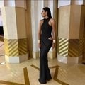 Detail of a sleek black maxi dress with halter neck, waist cut-outs, and elegant draping - S / Black