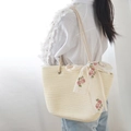 Detail of beige woven tote bag featuring floral lace ribbon and tubular shoulder straps - Off-White And Ribbon