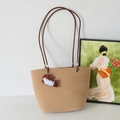 Khaki woven tote bag with brown shoulder straps and a small blue dog charm - Khaki And Apple Dog Charm