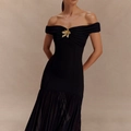 Detail of elegant black off-shoulder dress with a golden flower brooch and sheer mesh hem - S / Black