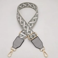Detail of adjustable gray geometric woven shoulder strap with gold metal lobster clasps - Beige Medium Gray + Light Gray Leather