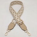 Detail of adjustable geometric jacquard bag strap with golden metal swivel hooks and leather - Apricot + Apricot Leather