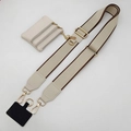 Detail van de verstelbare beige telefoonriem met gouden hardware en bijpassend portemonnee - Beige Riem Koffierand Gouden Haak En Cremewit Zakje