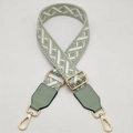Detail of green geometric woven bag strap with adjustable gold buckle and swivel clasp - Beige Green + Green Leather