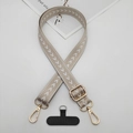 Macro detail of beige woven phone lanyard strap with golden metal clasp and black tether tab - T-Shaped Gasket / Khaki