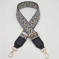 Detail of the golden metal snap hooks and geometric jacquard strap for crossbody bags - Black Border Khaki + Black Leather