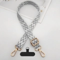Detail view of woven phone strap with lightning jacquard pattern and gold metal hardware - Grey and White Herringbone Jacquard (Style 5)
