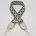 Detail van de jacquard geweven tasriem met geometrisch patroon en gouden metalen haken - Gouden Haak / Beige Basis Zwart Wit + Beige Leer