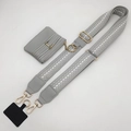 Detail view of adjustable polka dot shoulder strap with a small grey leather pouch and gold hardware - Gray Strap and Gray Pouch