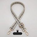 Detail of geometric woven strap with gold metal hooks and black phone tether tab - Beige White Gray
