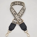 Detail of adjustable woven bag strap with ethnic floral pattern and gold metal hardware - Beige Base Black White + Black Leather