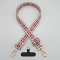 Detail view of pink geometric woven phone strap with gold lobster clasps and black patch - Beige White Rose Red