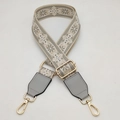 Close-up of adjustable ethnic floral embroidery bag strap with gold metal hooks - Beige Base Gray + Gray Leather