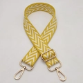 Nahaufnahme des gelb-weißen Zickzack-Gurtes mit verstellbaren goldenen Metallhaken - Silberhaken / Gelb