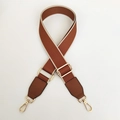 Detail view of brown wide fabric bag strap with golden metal lobster clasps and buckle - Brown + Brown Leather