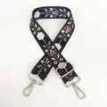 Detail of floral embroidery on wide crossbody strap with silver lobster clasps - Black and White Pattern / Silver