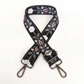 Detail of floral embroidery on black guitar strap with gunmetal swivel lobster clasps - Black and White Pattern / Gunmetal