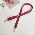 Detail showing burgundy nylon bag strap with gold metal hooks and adjustable buckle - Burgundy