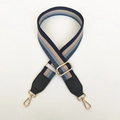 Detail van verstelbare tasriem met blauwe en grijze strepen en gouden karabijn - Blauwe Strepen + Zwart Leer