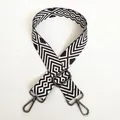 Dettaglio di un'ampia tracolla regolabile in tela con motivo a rombi bianchi e neri - Modello A15 (Gancio Gunmetal)