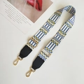 Close-up of ethnic woven bag strap with blue and yellow geometric patterns and gold clips - White Yellow and Black Leather Accent