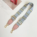 Close-up of ethnic geometric woven strap with golden hooks and pink leather accents - White Yellow and Pink Leather Accent