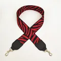 Dettaglio della tracolla larga in tela zebrata rossa e nera con ganci in metallo oro - Nero + Rosso