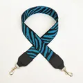 Close-up of zebra pattern woven shoulder strap with gold lobster clasps and leather ends - Black+Blue