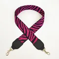 Macro view of wide zebra print strap with rose red and black weave and gold buckle - Black+Rose Red